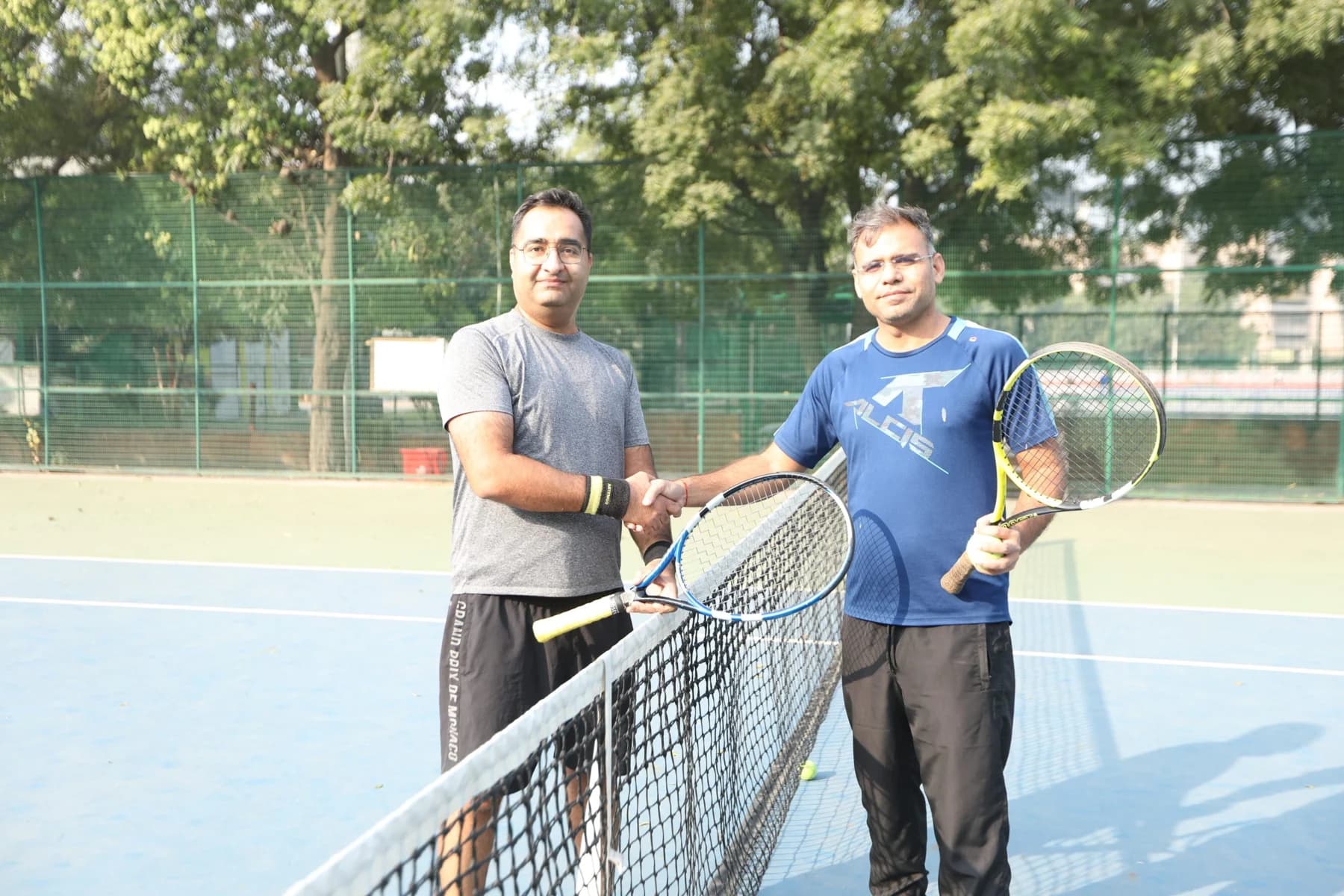 Two tennis players with rackets on an outdoor RGT court