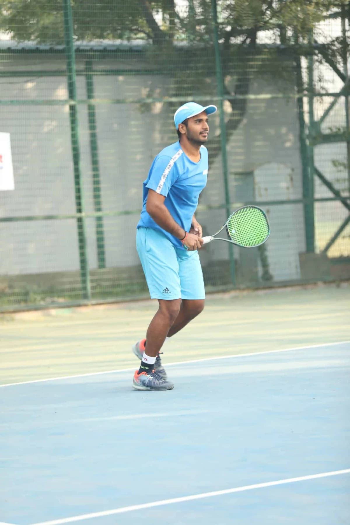 RGT player in blue holding a racket ready to receive