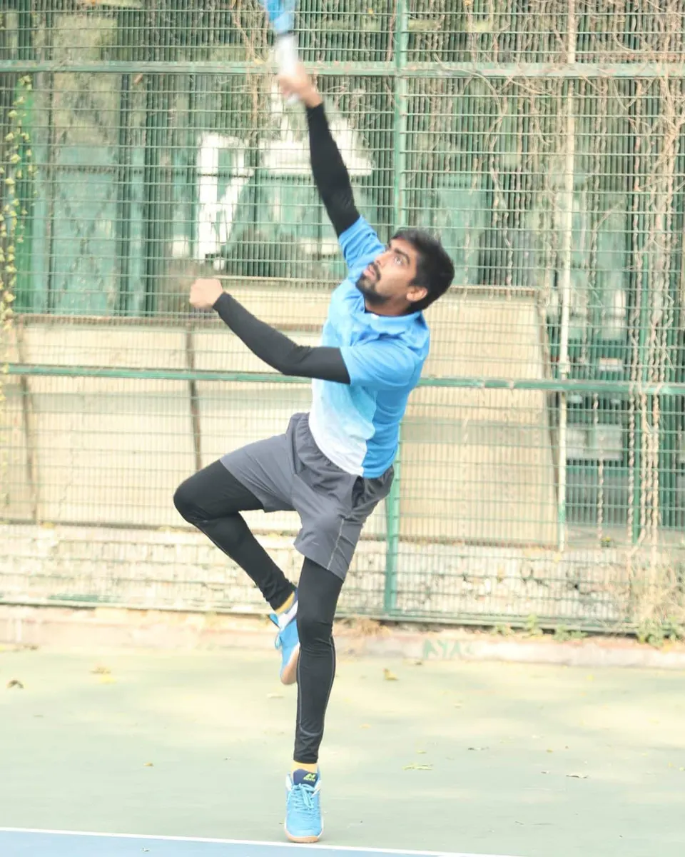 A player stretches high for an overhead