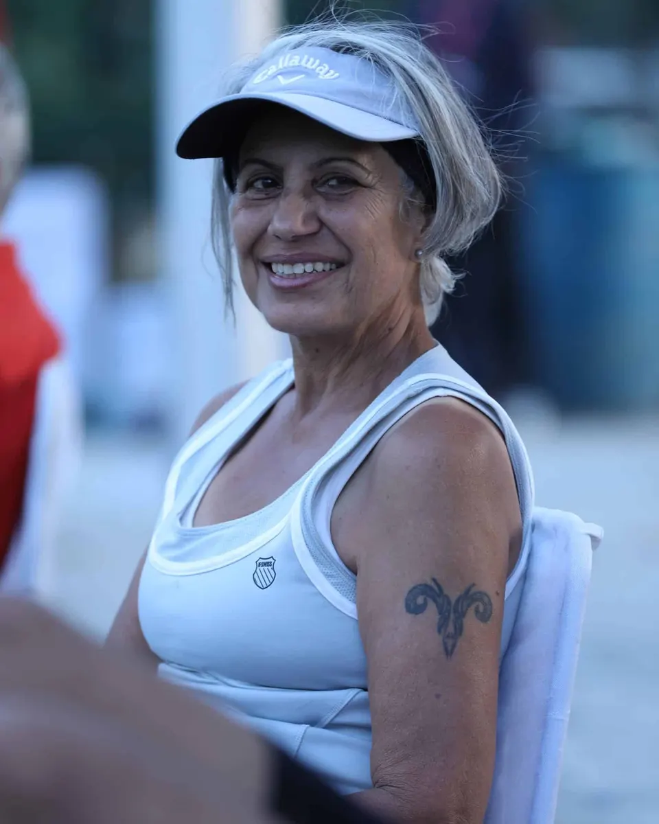 A smiling masters player courtside